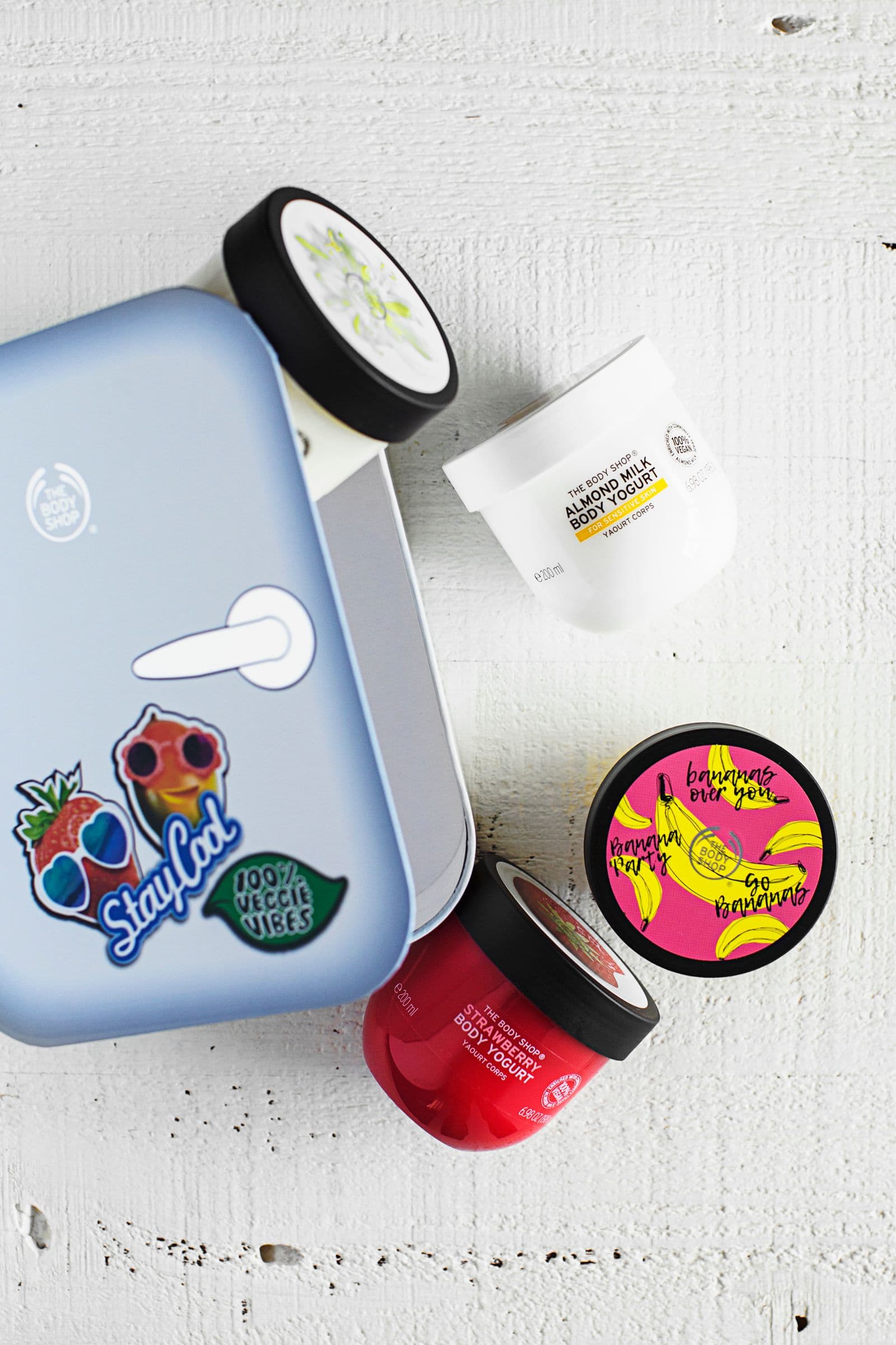 Selection of The Body Shop Body Yogurts on a white background next to a themed box.