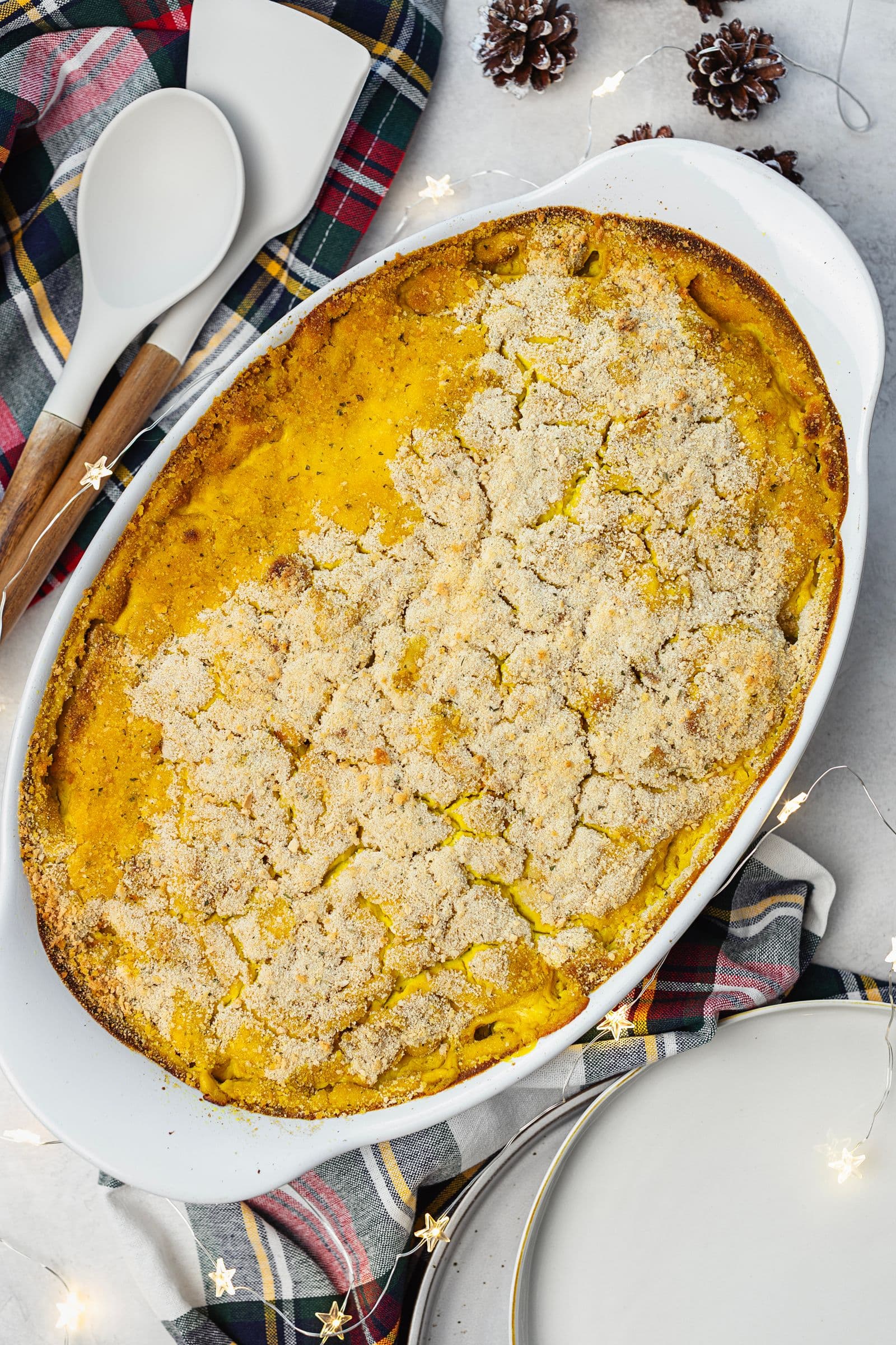 Baked vegan gratin with a golden breadcrumb crust in a white casserole dish.