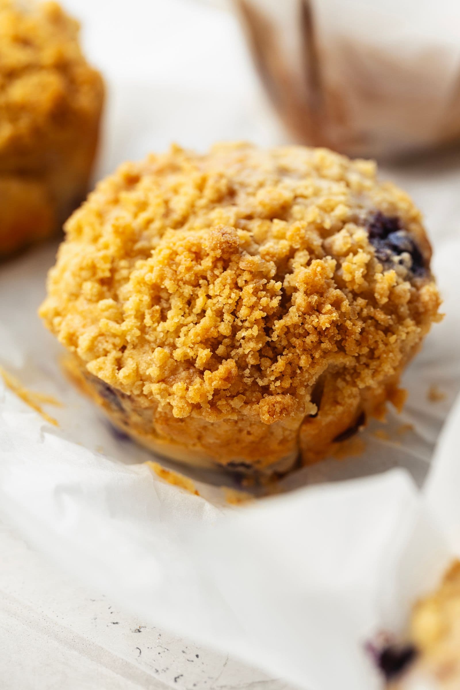 Close-up of a lemon and blueberry streusel muffin showing the golden crumb and crunchy topping.