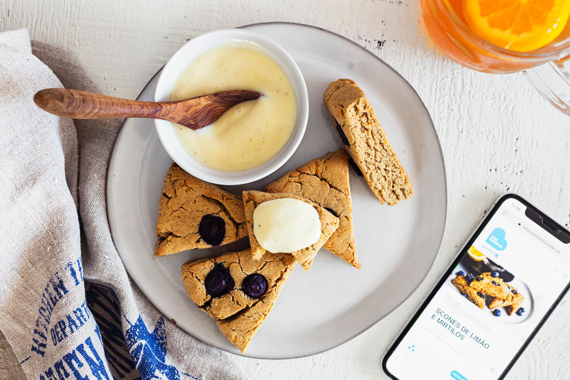 Vegan lemon and blueberry scones served with cream on a plate.