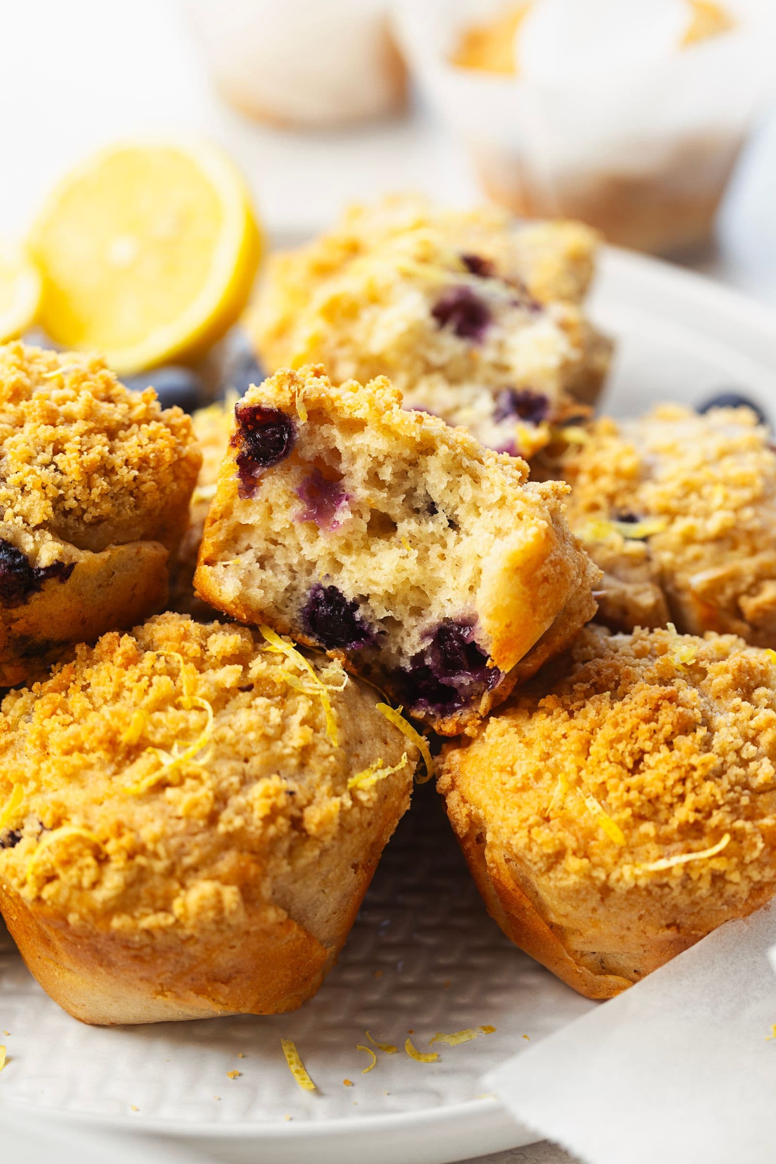 Lemon blueberry muffin cut in half, revealing a soft crumb with juicy blueberries inside.
