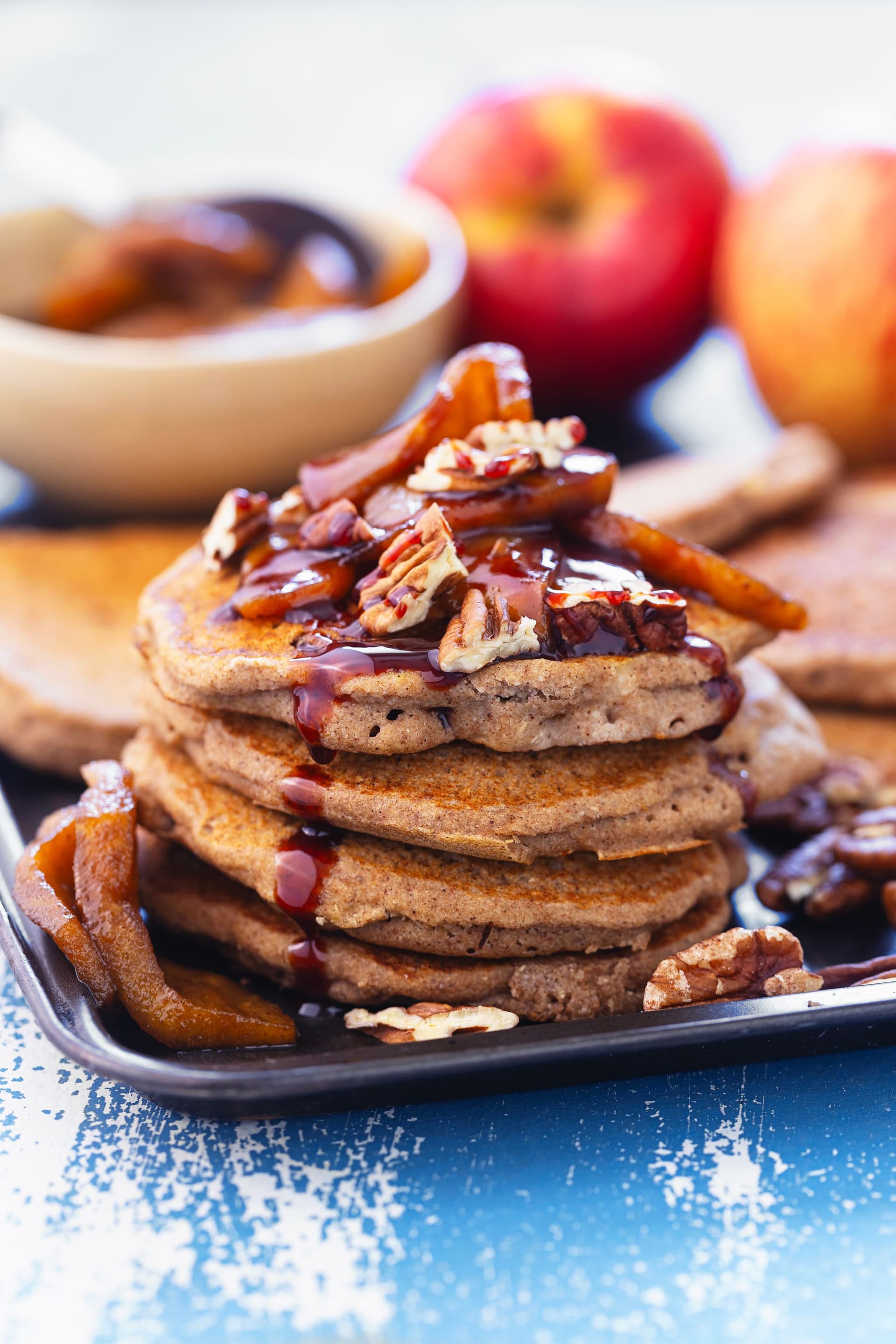 Close-up of fluffy pancakes topped with coconut caramel apples and syrup.