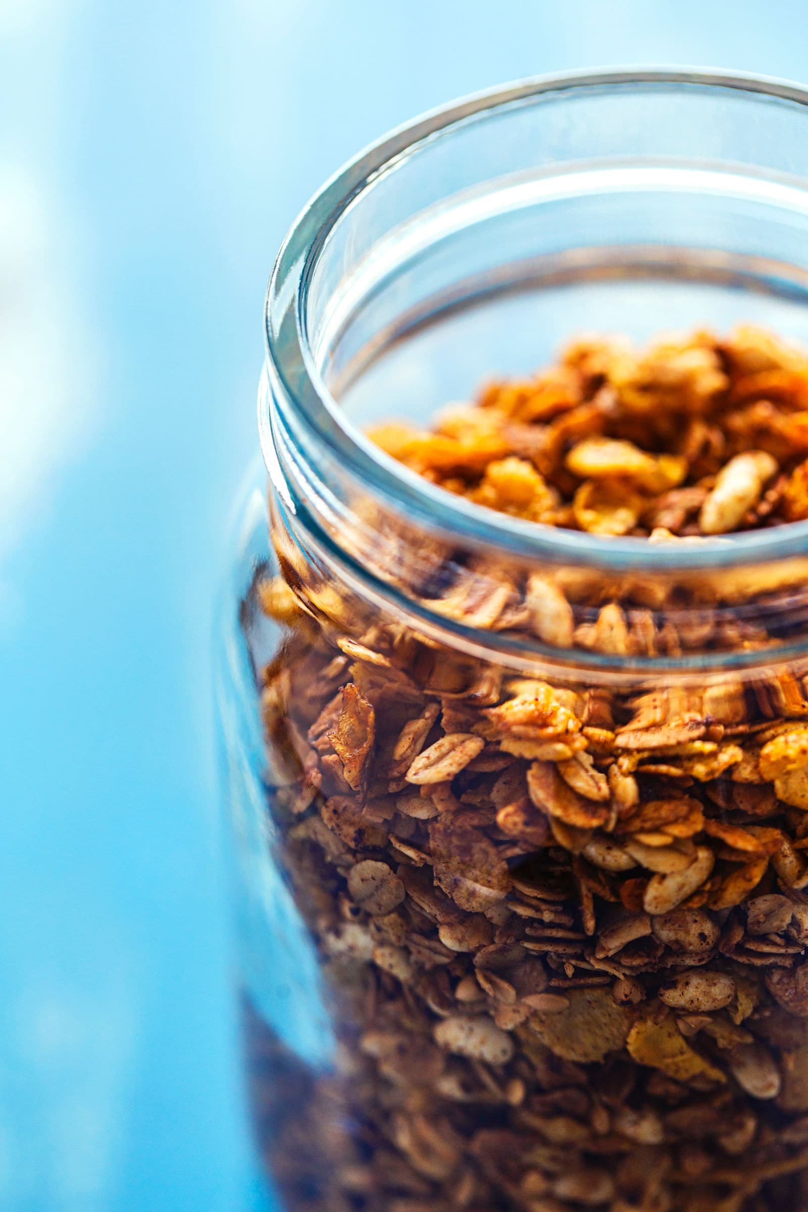 Close-up of golden, crunchy granola stored in a glass jar.